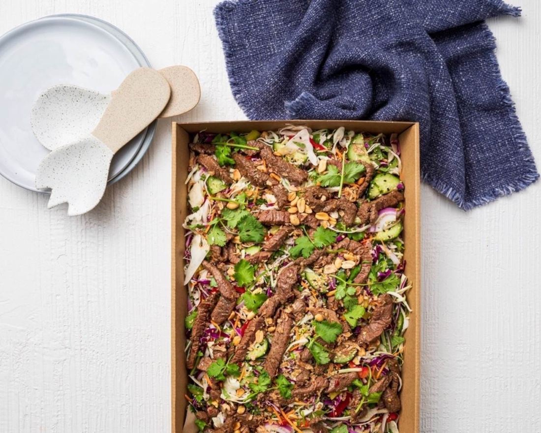 Thai beef salad platter with serving spoons